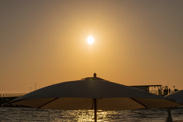 beach umbrella against the sea sunset. pier