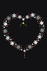 Christmas heart shape wreath decoration, white snowflakes, stars, mistletoe, red holly berries. Ornate festive design romantic symbol of love Xmas theme.