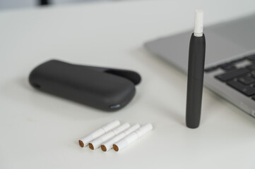 Tobacco heating system next to a laptop. 