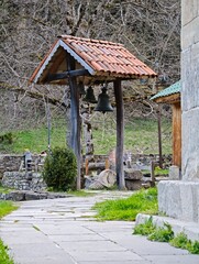 Bells hanging in a small belfry with tiled roof in Nekresi Monastery