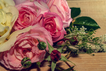 Bouquet of pink roses, peonies on a light wooden background.