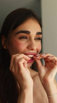 A young woman happily showcases her clear aligners, demonstrating how easy it is to incorporate them into a daily routine for a confident smile. She exudes joy and enthusiasm.