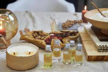 A creative workspace with tools, wax, dried flowers, and a ceramic bowl during the process of...
