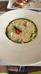 Risotto carbonara with pesto sauce served at restaurant