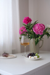 An Elegant Floral Arrangement Accompanied by Refreshing Wine and Delicious Fruits