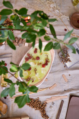 Top view close-up of a handcrafted candle in a ceramic bowl, decorated with dried flowers and autumn elements. A cozy and aesthetic arrangement on a table, reflecting the themes of slow living