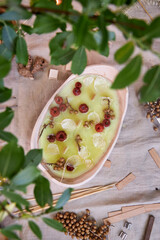 Top view close-up of a handcrafted candle in a ceramic bowl, decorated with dried flowers and autumn elements. A cozy and aesthetic arrangement on a table, reflecting the themes of slow living