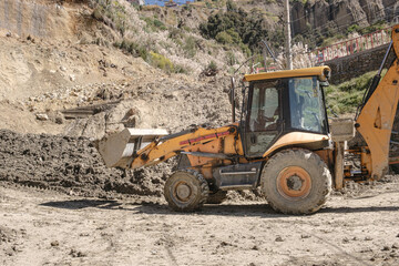 tractor moving earth from a landslide in the city of la paz, bolivia - cleanup concept