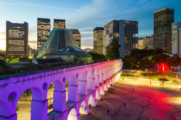 Lapa Aqueduct Illuminated With Purple and Pink Colors in the Evening With Tall Office Buildings of Rio de Janeiro Downtown