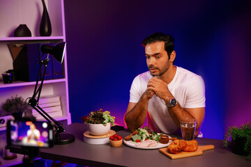 Healthy influencer in host channel presenting fresh vegetables in special dish of salad with brest...