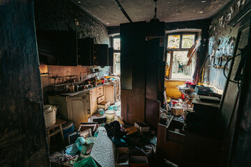 Naklejka premium Dark, moody kitchen in an abandoned house, filled with scattered and dusty objects. A chaotic scene frozen in time and decay.