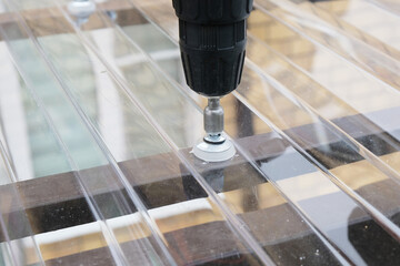 Process of installing a roofing material for a canopy made of transparent polycarbonate, tightening the fasteners, a thermal washer and a self-tapping screw close-up