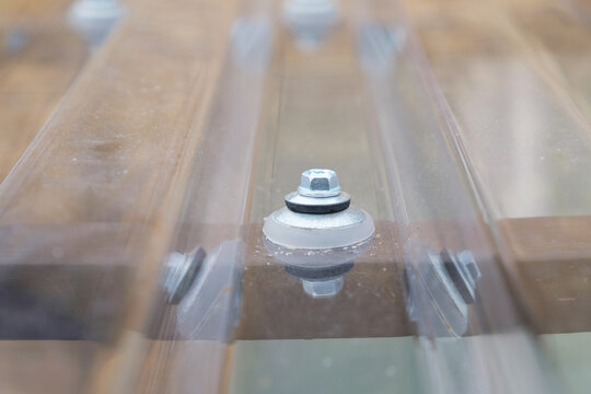 Thermal washer - fastening element for profiled polycarbonate, close-up. - Powered by Adobe