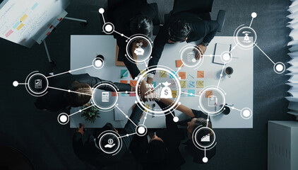 A team of professionals discusses tax strategies in a modern office, surrounded by digital icons representing various financial concepts and data analysis techniques. Amity