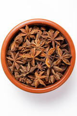 A clay bowl full of Anis on a kitchen countertop in a zenithal photograph
