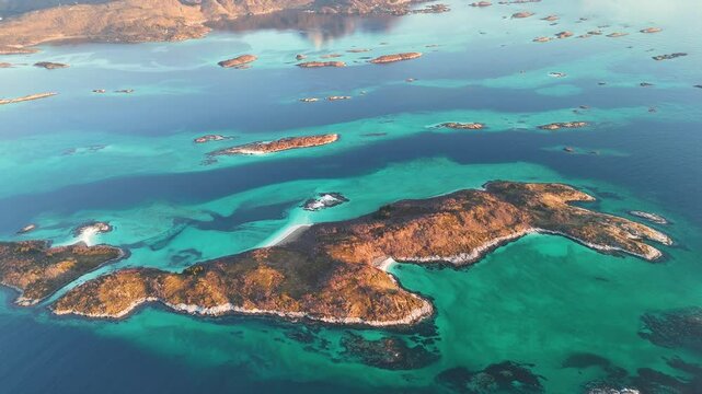 Scenery of blue waters and green mountains with remnants of snow in spring under clear skies on the island of Senja, Senja municipality, Troms county, Norway, Europe. Tourist area
