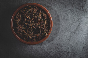 A clay bowl full of Anis on a kitchen countertop in a zenithal photograph
