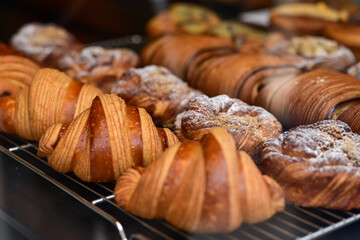 Golden flaky croissants  and  pastry sweets with toppings displayed in a  frech  bakery  at Monaco
Delicious croissants on the store showcase.
