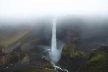 Haifoss waterfall plunges through mist and volcanic cliffs in Icelands Highlands. A breathtaking...