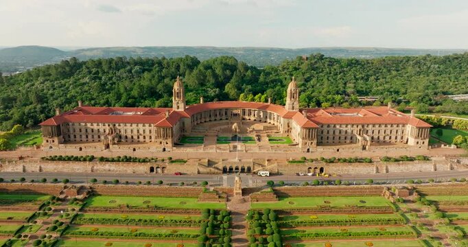 Aerial perspective of Union Buildings in Pretoria, South Africa. Majestic architecture, expansive garden and lawns, and panoramic city views. 4K zoom out establishing drone video
