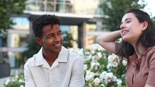 Young couple talking and laughing together on a bench