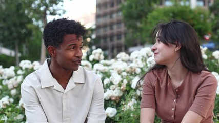 Young couple talking and smiling in urban park - Powered by Adobe