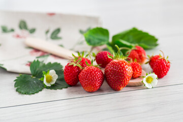 Appetizing red strawberries on a light wooden table
