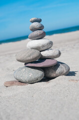 Balanced rock pyramid on sea sand beach