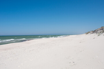 Sandy beach and sea waves by sunny summer day