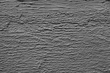 The texture of rough, embossed grey plaster.