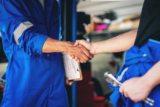 Two men shake hands in a blue uniform