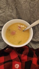 woman holding bowl of broth in winter wearing red pajamas