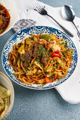 Lagman Noodles with Meat and Vegetables on Blue Plate