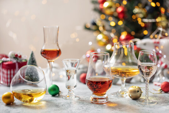 Assortment of strong alcoholic beverages in glasses on a Christmas background