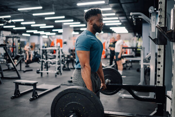 Determined bodybuilder lifting weights in modern gym