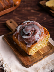 Sweet cinnamon roll on a wooden board on a rustic table