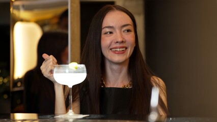 Smiling beautiful woman zipping Margarita cocktail savoring tasty drink making special time by bartender at luxurious bar creating moment meeting with friends or a couple vibrant nightclub. Vinosity.