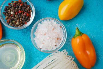 various cooking ingredients with noodles and vegetables on blue background