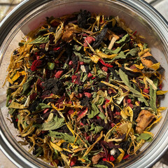 Herbal aromatic tea. Dry tea leaves in a jar - calendula, lingonberry, mint.