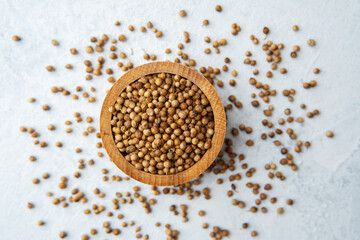 wooden bowl  with coriander seeds on white background