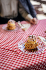 A plate of cream-filled profiteroles elegantly served on the terrace table
