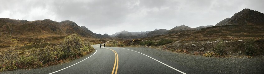 Panoramic Road with Misty Mountains and People Walking