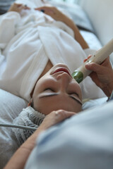 closeup portrait  of young woman receives a HIFU (High-Intensity Focused Ultrasound) facial treatment at a modern aesthetic clinic. 