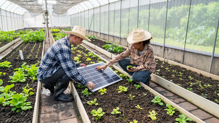 Farmers planning to install solar panels on their farm to power greenhouses for crop production,...