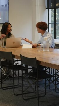 Vertical video: Diverse colleagues pointing text, signing contract, shaking hands at table