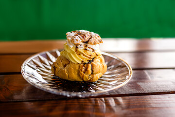 A plate of cream-filled profiteroles elegantly served on the terrace table