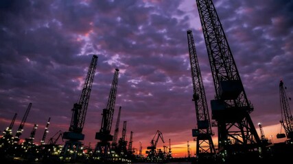 Dramatic sunset footage highlighting silhouette views of industrial cranes and structures in a large-scale petrochemical complex, symbolizing industrial growth and energy infrastructure - Powered by Adobe