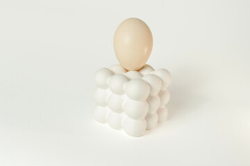 White egg placed on a modern bubble-style egg holder on isolated white background. 