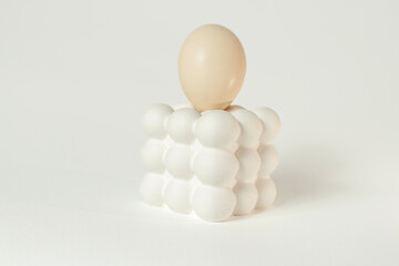 White egg placed on a modern bubble-style egg holder on isolated white background. 