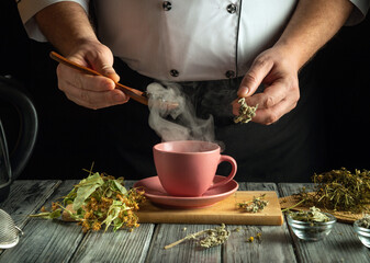 A person dressed in a chef's coat skillfully prepares herbal tea. Steam rises from a pink cup as...